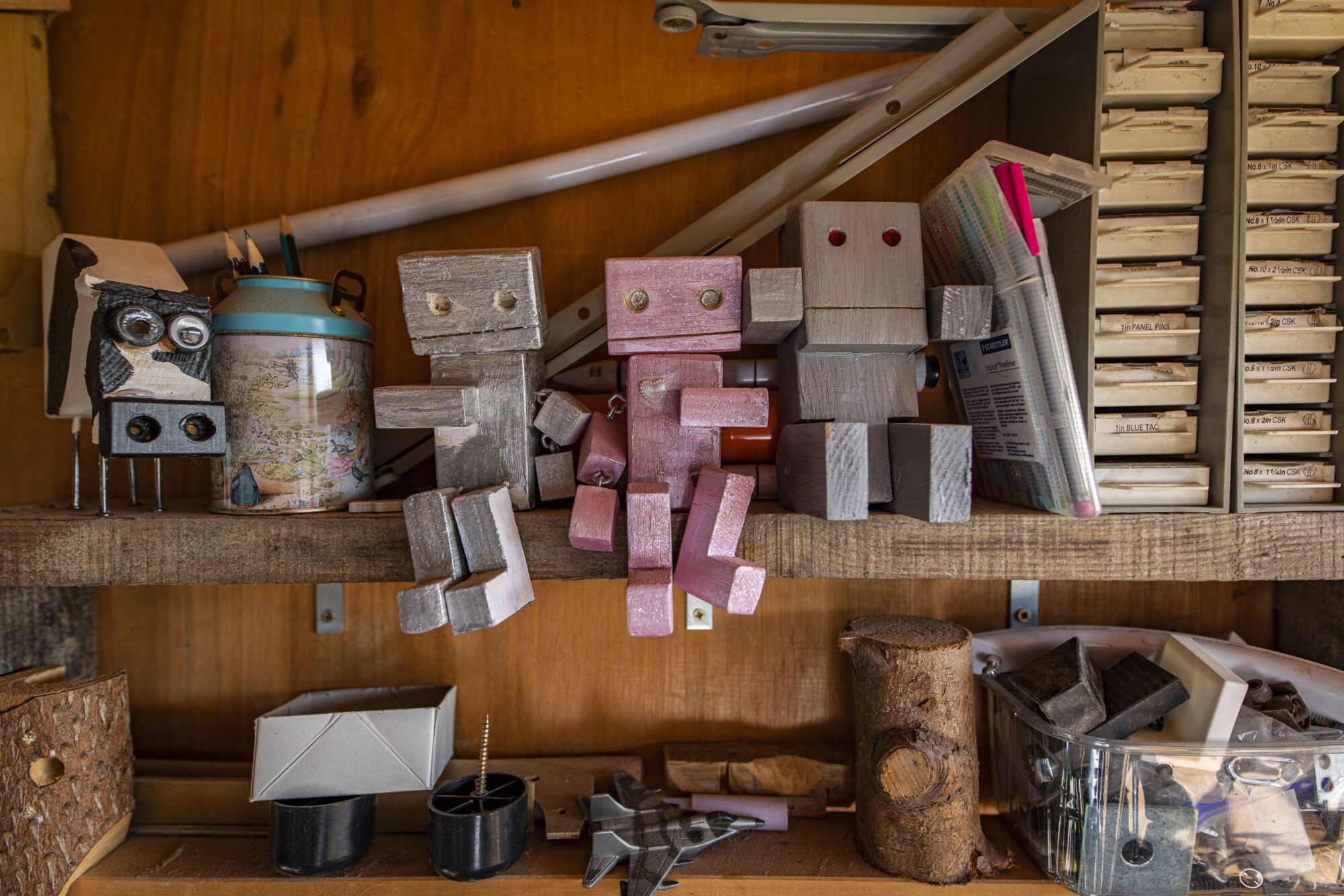 Woodworking shed shelf with wooden robots.